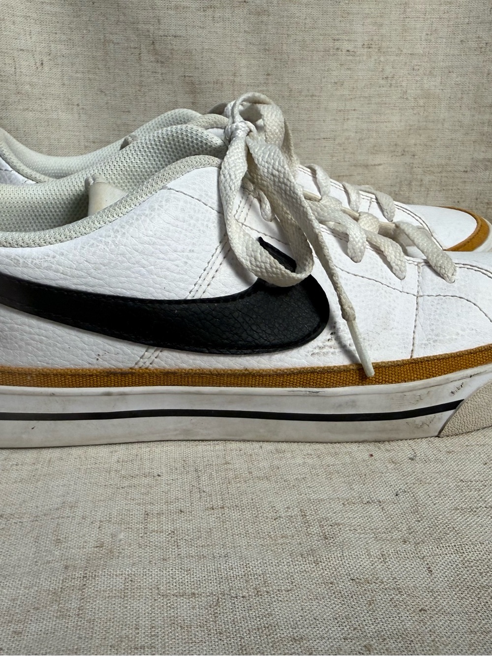 Nike White Low-Top Sneakers with Black Swoosh and Gold Accent